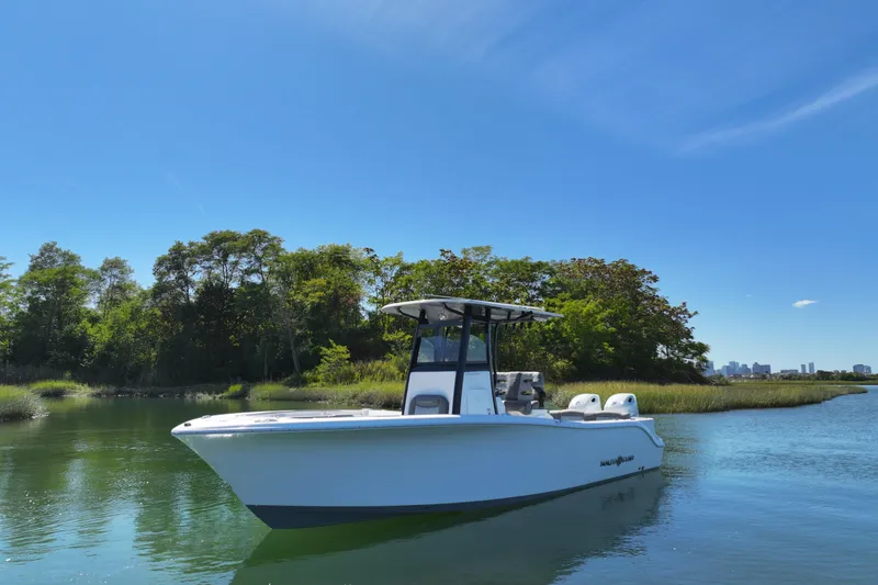 Slide: The Image of 2026 NauticStar 252 Legacy boat on calm water, surrounded by lush greenery. - 12
