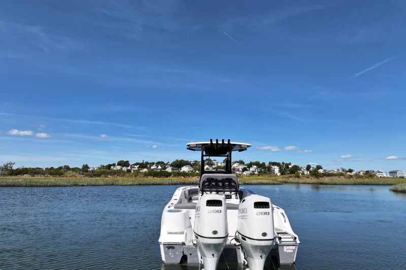 Slide: The Image of 2026 NauticStar 252 Legacy boat on calm water under clear blue sky. - 19