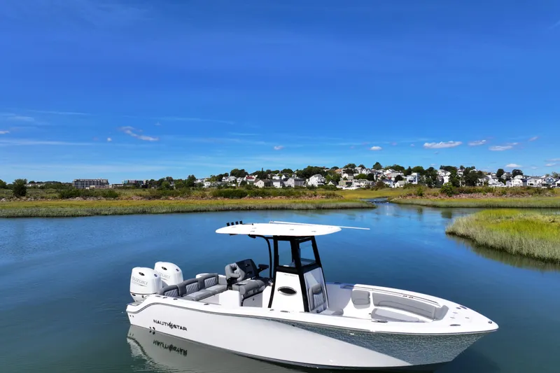 Slide: The Image of 2026 NauticStar 252 Legacy boat on serene water with scenic background. - 4