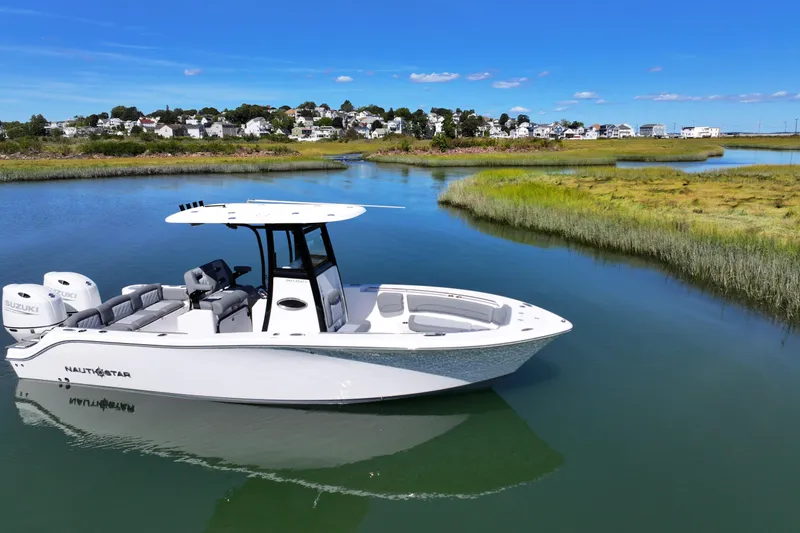 Slide: The Image of 2026 NauticStar 252 Legacy boat on serene waterway with scenic background. - 5