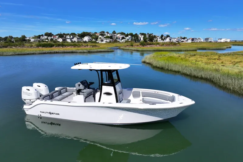Slide: The Image of 2026 NauticStar 252 Legacy boat on calm water with scenic background. - 6
