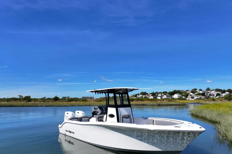 Slide: The Image of 2026 NauticStar 252 Legacy boat on calm water under clear blue sky. - 8