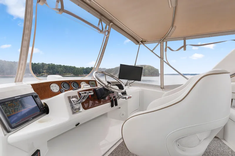 Slide: The Image of 2005 Silverton 34 Convertible helm with modern controls and scenic water view. - 13