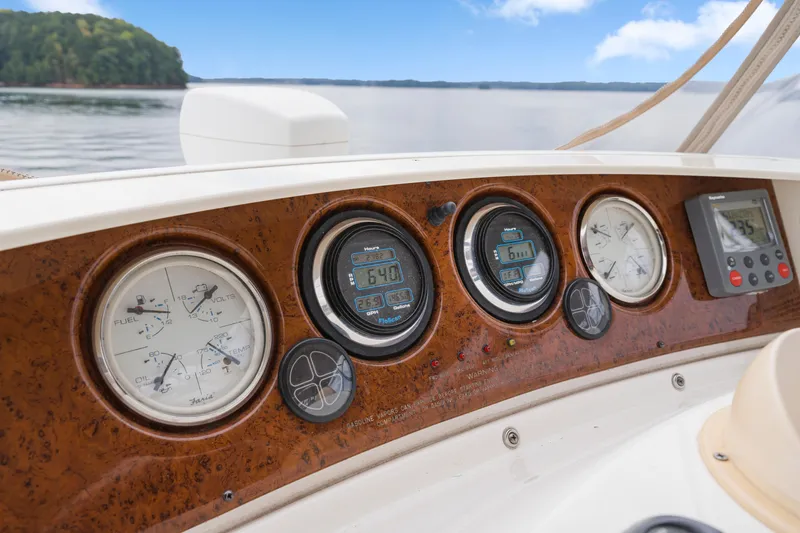Slide: The Image of Dashboard of 2005 Silverton 34 Convertible boat with gauges and controls, overlooking serene water. - 18
