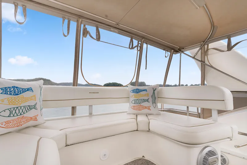 Slide: The Image of Interior of 2005 Silverton 34 Convertible yacht with white seating and decorative fish pillows. - 23