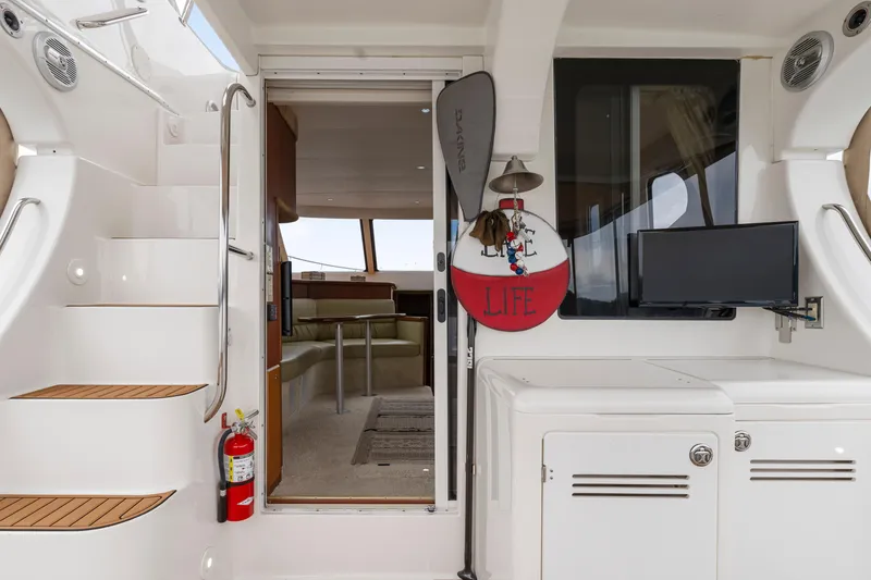 Slide: The Image of 2005 Silverton 34 Convertible yacht interior with stairs, seating, and mounted TV. - 25
