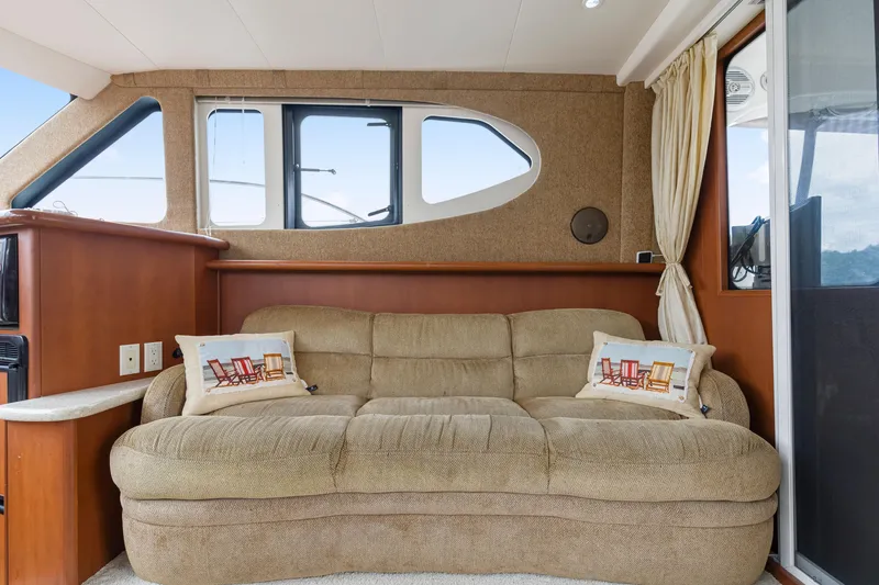 Slide: The Image of Interior of 2005 Silverton 34 Convertible yacht with beige sofa and decorative pillows. - 5