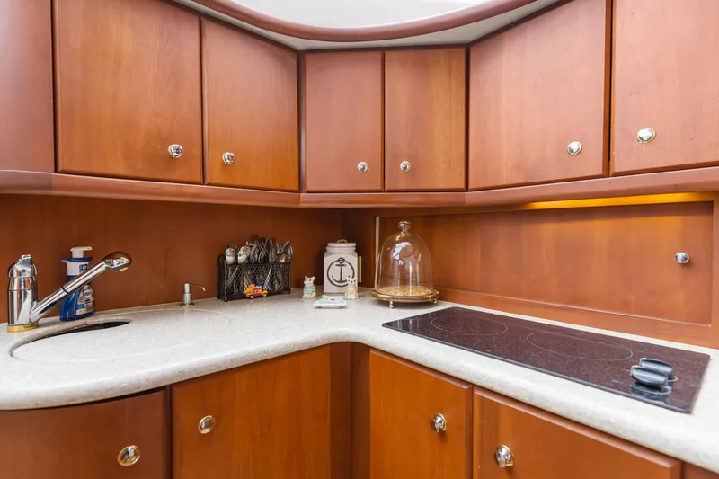 Slide: The Image of 2005 Silverton 34 Convertible yacht kitchen with wooden cabinets and modern appliances. - 9