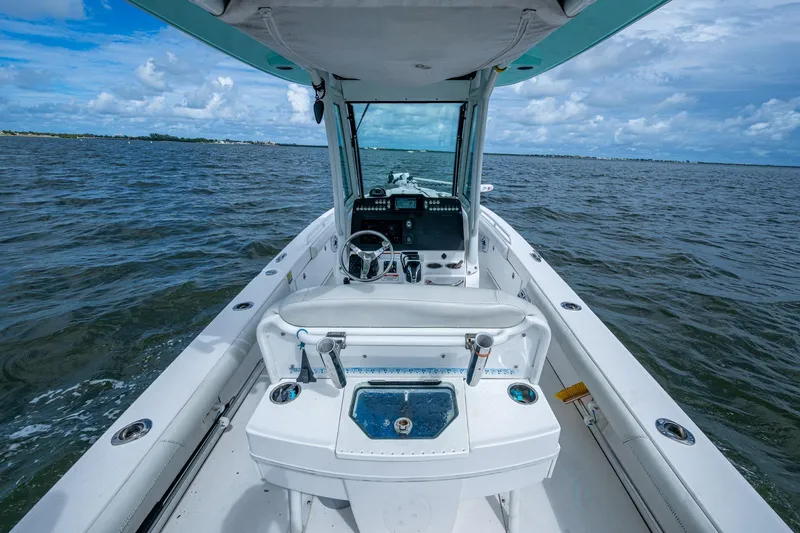 Slide: The Image of 2021 Everglades 253 Center Console boat on open water, showcasing helm and seating area. - 20