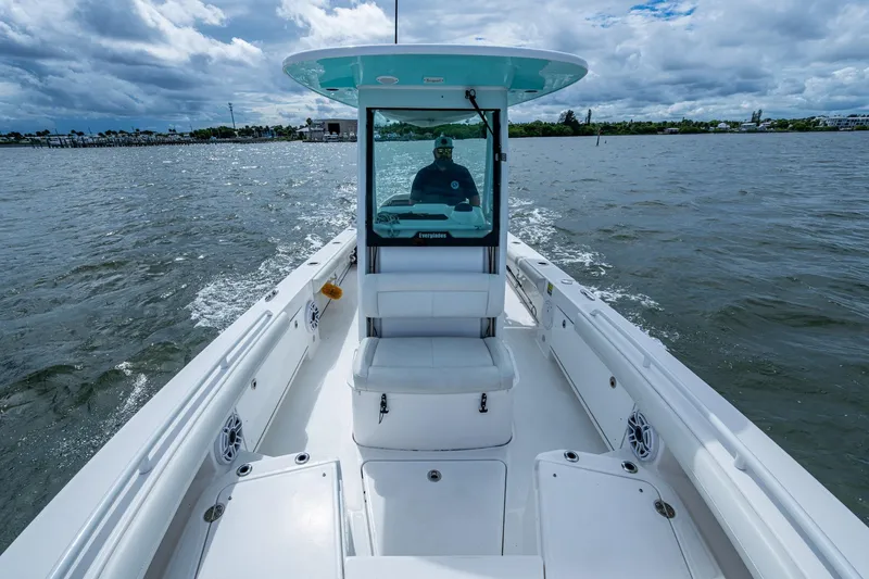 Slide: The Image of 2021 Everglades 253 Center Console boat cruising on open water under cloudy skies. - 21
