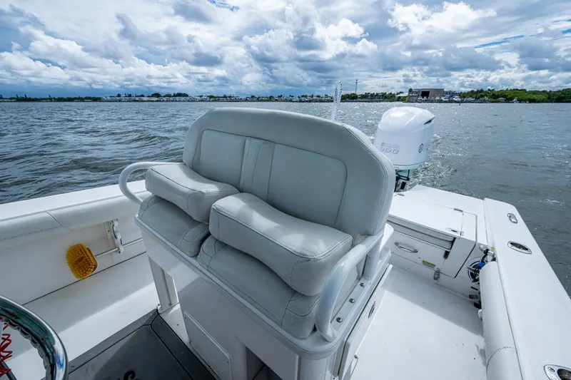 Slide: The Image of 2021 Everglades 253 Center Console boat with cushioned seating, on a calm water body. - 23