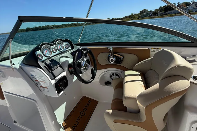 Slide: The Image of 2025 NauticStar 243 DC Deck boat interior with steering wheel and comfortable seating. - 14