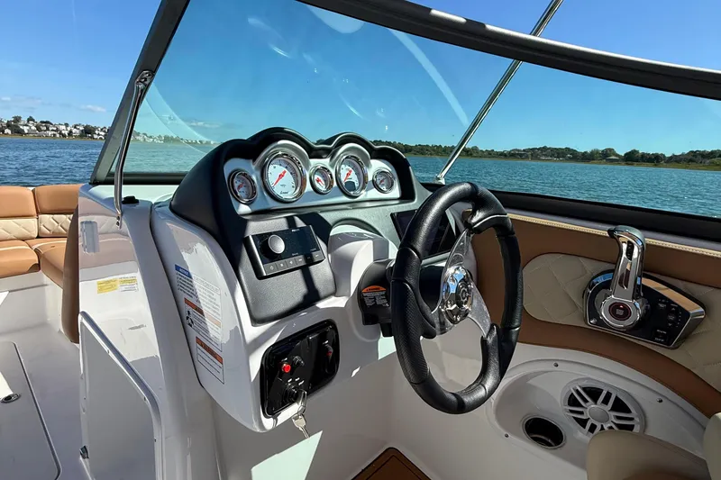 Slide: The Image of 2025 NauticStar 243 DC Deck boat interior with steering wheel and control panel. - 19