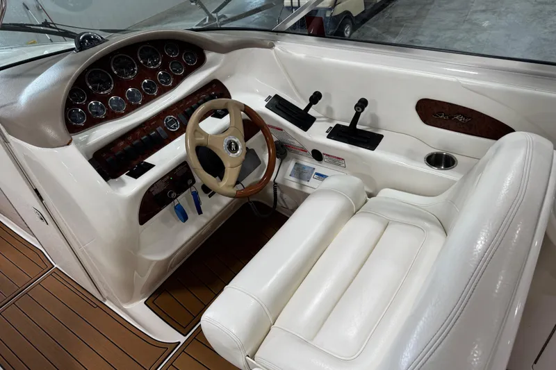 Slide: The Image of 2001 Sea Ray 280 Bow Rider cockpit with white leather seat and wooden dashboard. - 9
