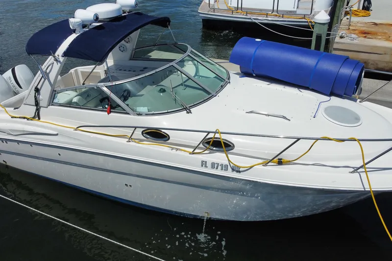 The Image of 2005 Monterey 302 Cruiser docked with blue cover and yellow ropes. - 0