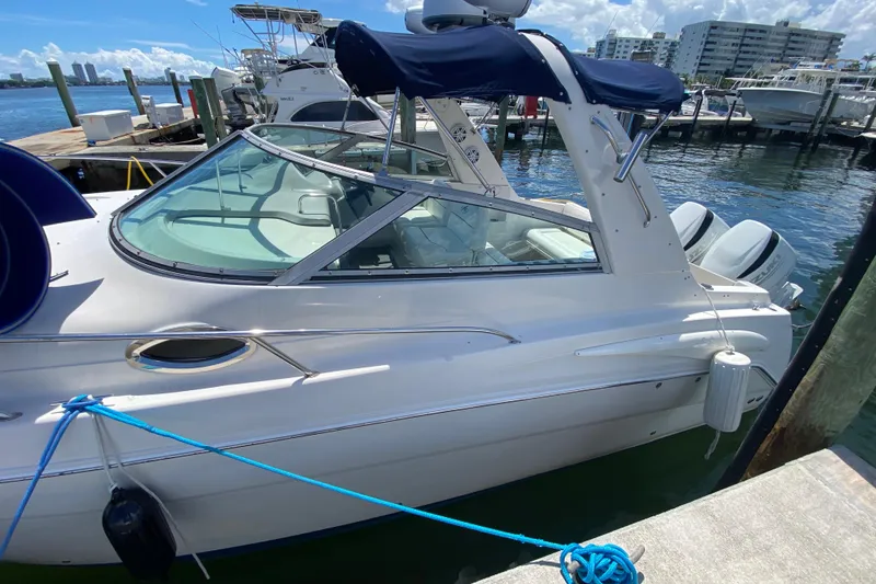 Slide: The Image of 2005 Monterey 302 Cruiser docked at marina, featuring sleek design and twin engines. - 11