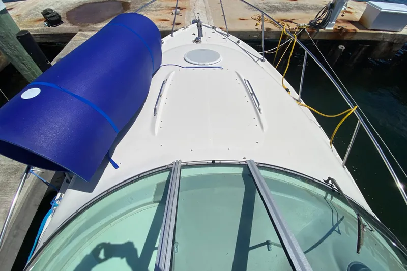 Slide: The Image of 2005 Monterey 302 Cruiser boat docked, featuring a blue cover and yellow cables. - 13