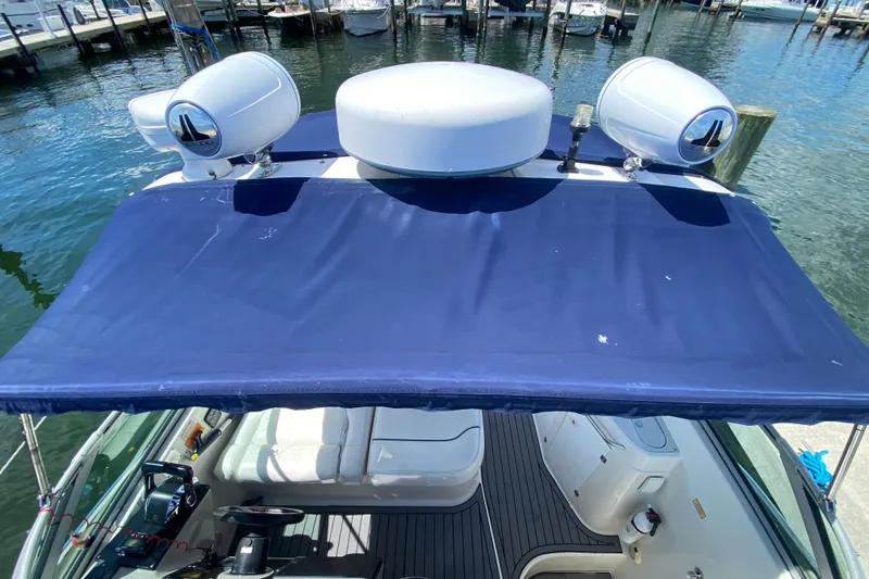 Slide: The Image of 2005 Monterey 302 Cruiser with blue canopy docked at marina. - 15