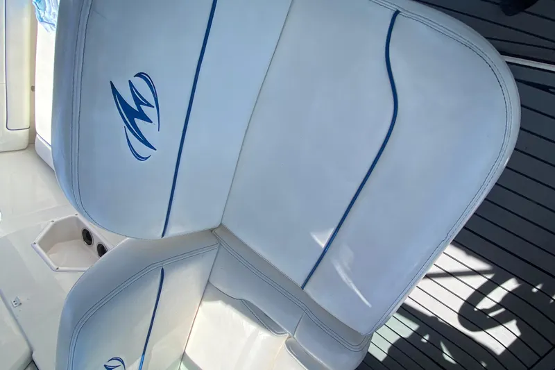 Slide: The Image of White leather seats on a 2005 Monterey 302 Cruiser boat, featuring blue accents. - 19