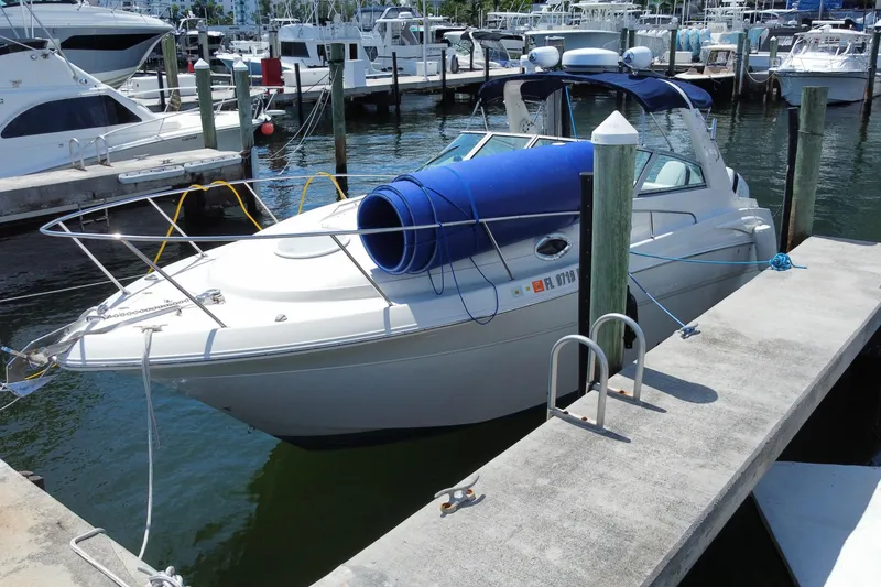Slide: The Image of 2005 Monterey 302 Cruiser docked at a marina, featuring a blue canopy. - 2