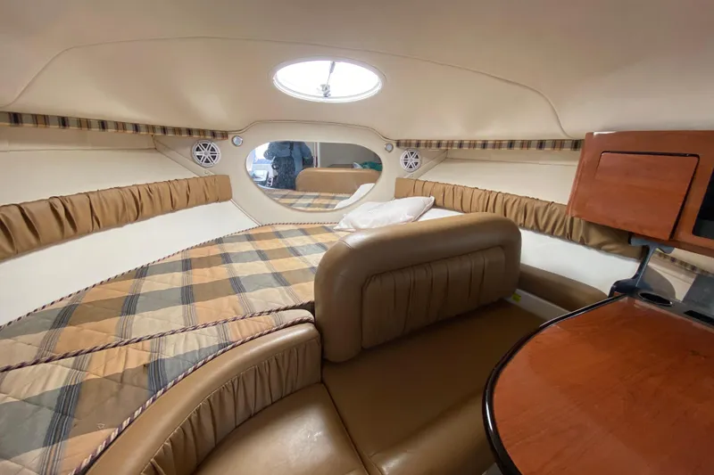 Slide: The Image of 2005 Monterey 302 Cruiser cabin interior with cozy seating and plaid bedding. - 22