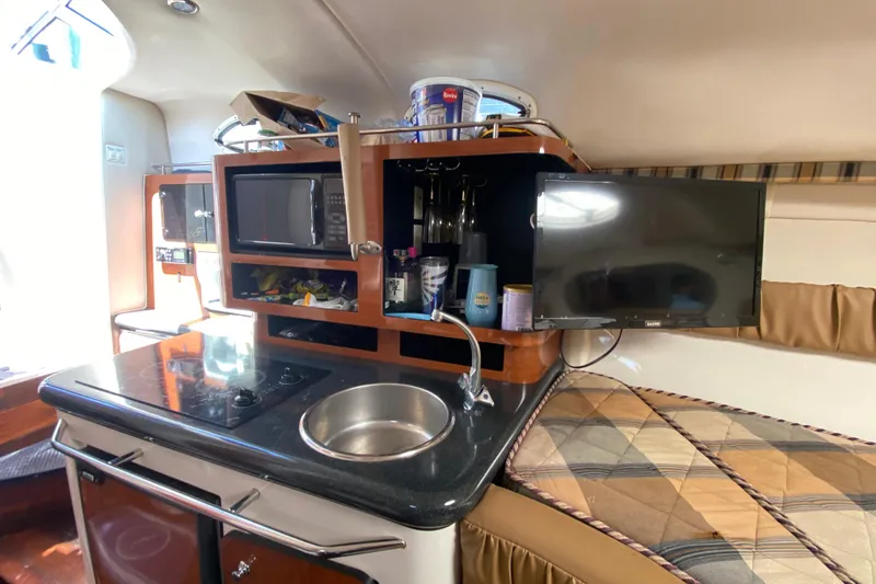 Slide: The Image of 2005 Monterey 302 Cruiser interior with kitchenette, sink, microwave, and TV. - 24