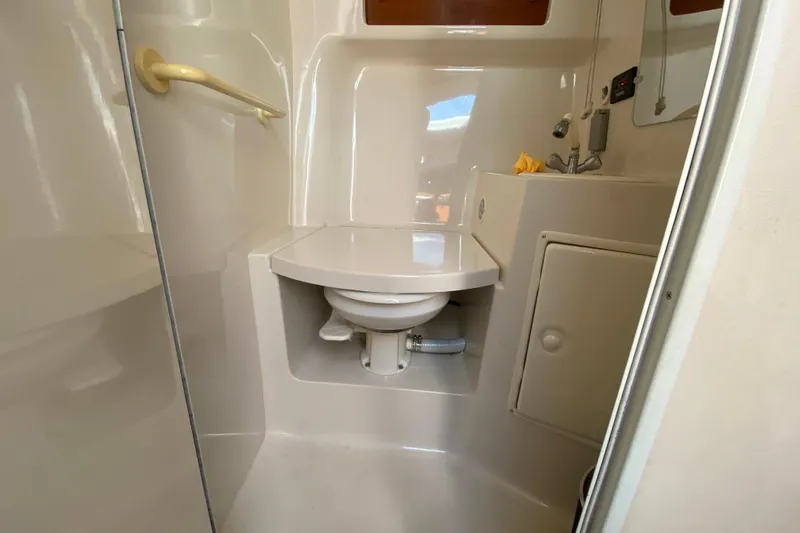 Slide: The Image of Bathroom interior of 2005 Monterey 302 Cruiser boat, featuring compact toilet and sink. - 25
