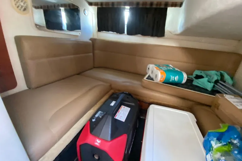 Slide: The Image of Interior of a 2005 Monterey 302 Cruiser with beige seating and various items. - 26