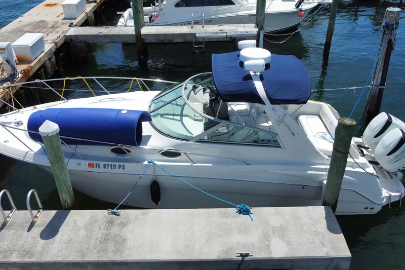 Slide: The Image of 2005 Monterey 302 Cruiser docked at marina with blue canopy and twin engines. - 27