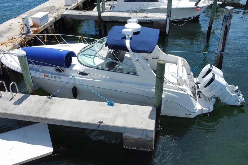 Slide: The Image of 2005 Monterey 302 Cruiser docked at marina with blue canopy and twin outboard engines. - 29