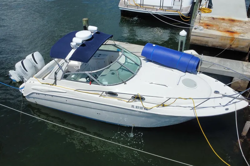 Slide: The Image of 2005 Monterey 302 Cruiser docked, featuring dual outboard motors and a blue canopy. - 30