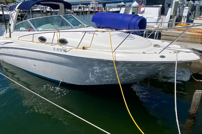 Slide: The Image of 2005 Monterey 302 Cruiser docked at marina, featuring sleek design and blue canopy. - 8