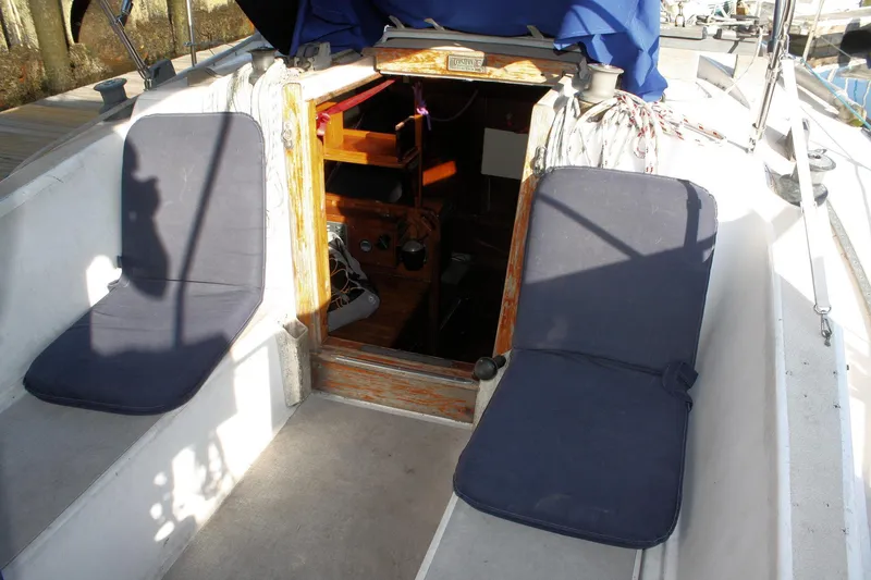 Slide: The Image of 1976 Tartan 38 sailboat cockpit with blue cushions and open cabin entrance. - 17