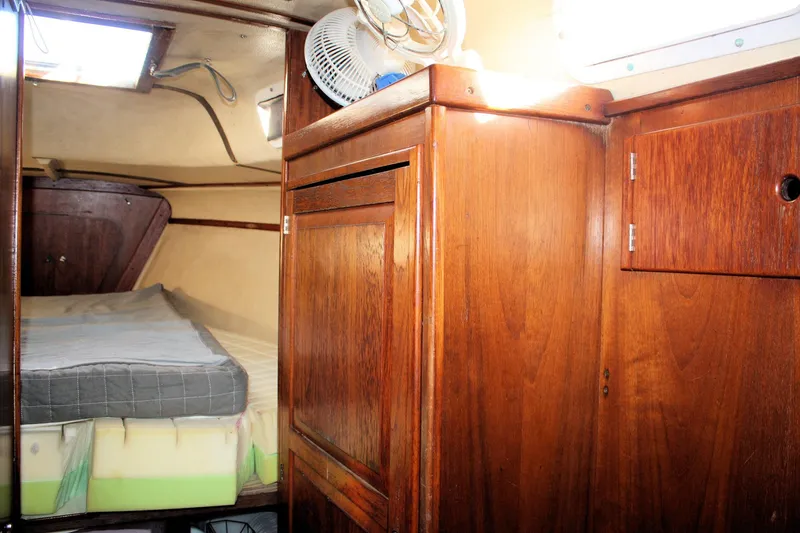 Slide: The Image of 1976 Tartan 38 yacht interior with wooden cabinetry and cozy sleeping area. - 19