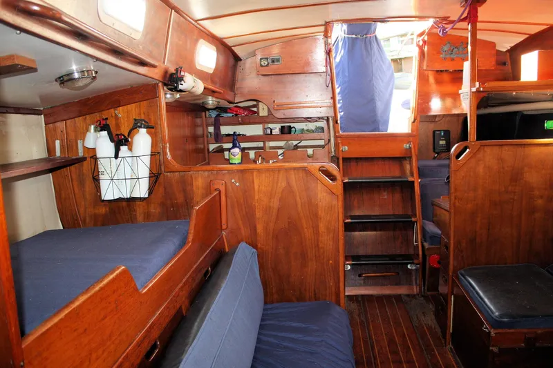 Slide: The Image of Interior of a 1976 Tartan 38 sailboat with wooden furnishings and blue cushions. - 25