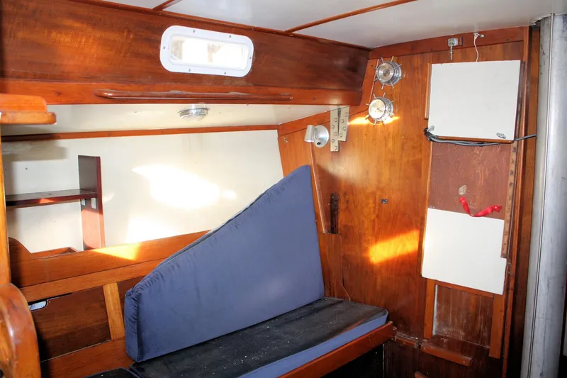 Slide: The Image of 1976 Tartan 38 sailboat interior with wooden paneling and blue cushion. - 28
