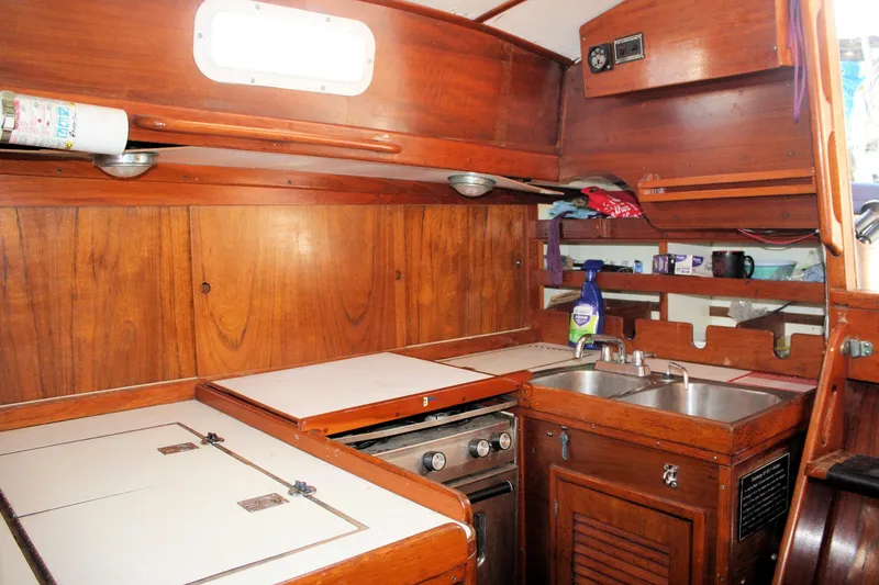 Slide: The Image of 1976 Tartan 38 yacht interior kitchen with wooden cabinetry and stainless steel sink. - 33