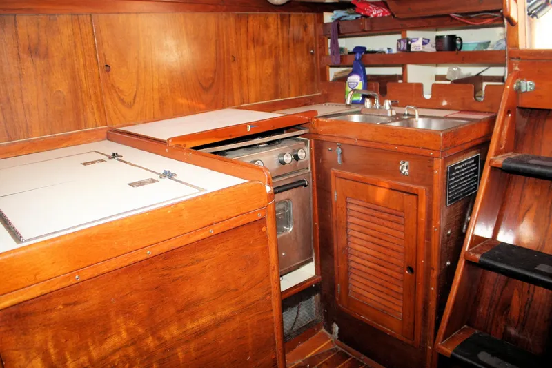 Slide: The Image of 1976 Tartan 38 yacht interior with wooden cabinetry, stove, and sink. - 34