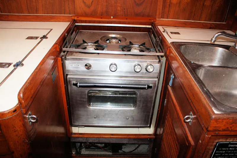 Slide: The Image of 1976 Tartan 38 yacht kitchen with stove, oven, and stainless steel sink. - 39