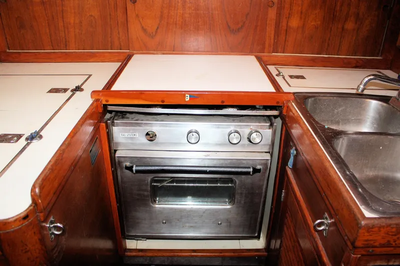 Slide: The Image of 1976 Tartan 38 yacht kitchen with stainless steel oven and wooden cabinetry. - 40