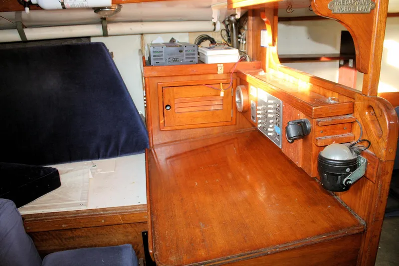 Slide: The Image of 1976 Tartan 38 yacht interior with wooden navigation desk and control panel. - 42