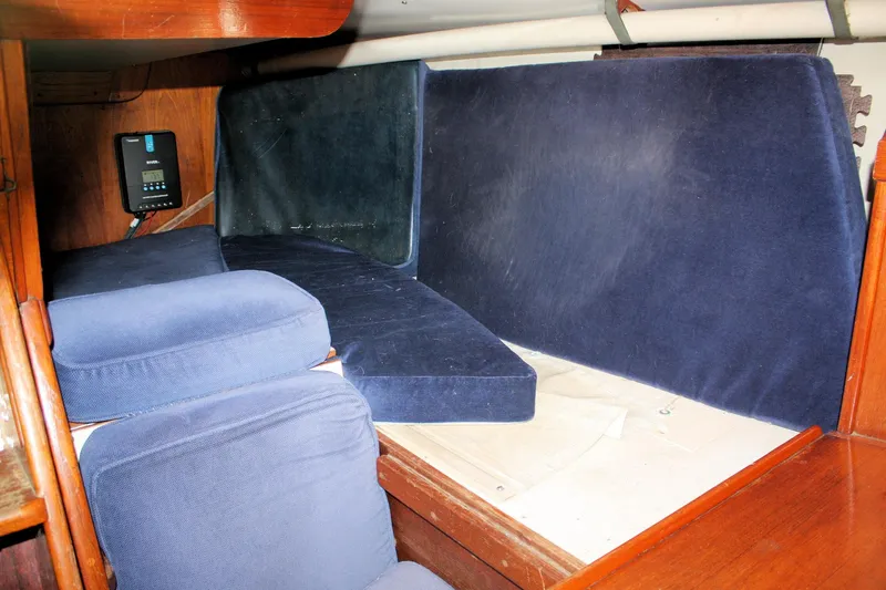 Slide: The Image of Interior cabin of a 1976 Tartan 38 sailboat with blue cushions and wooden paneling. - 43