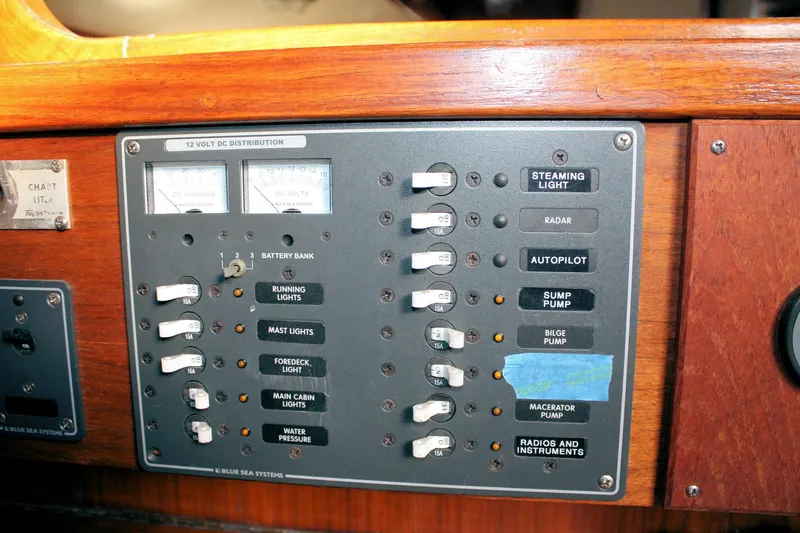 Slide: The Image of Electrical control panel on a 1976 Tartan 38 sailboat, featuring various switches and gauges. - 46