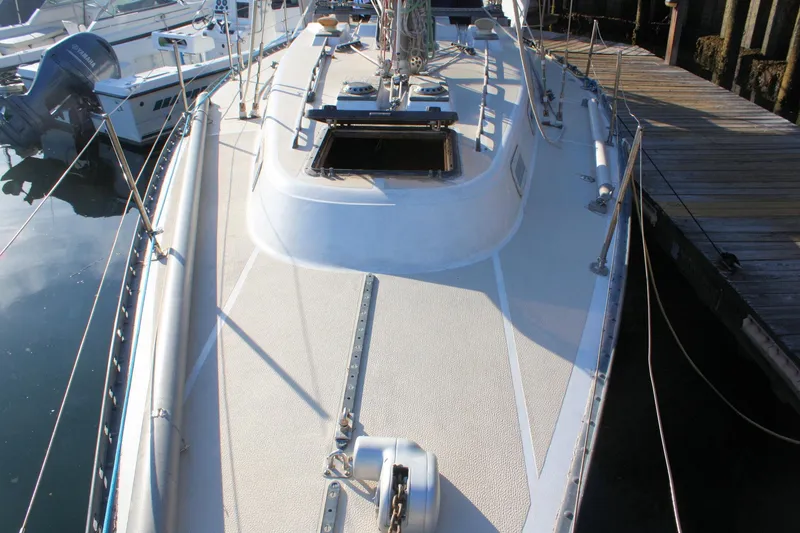 Slide: The Image of 1976 Tartan 38 sailboat docked, showcasing deck and open hatch. - 7