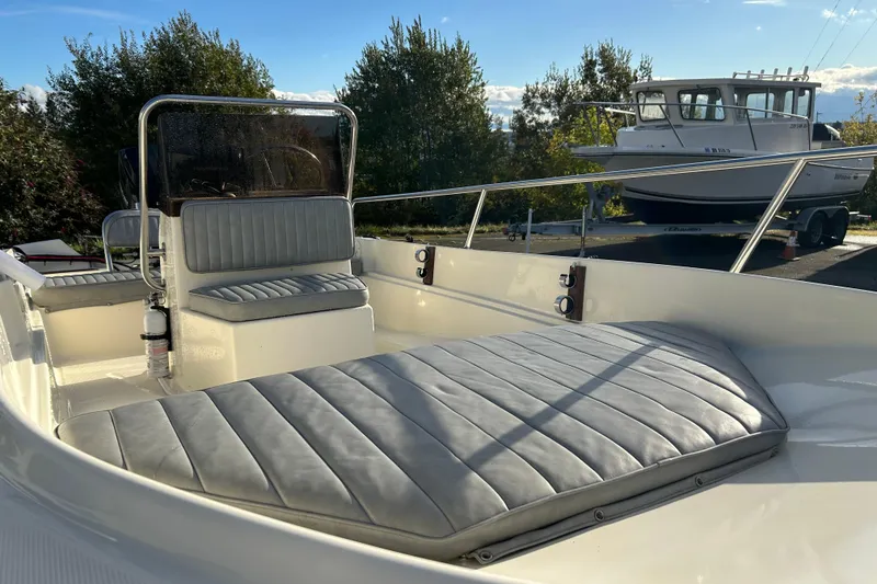 Slide: The Image of 1990 Wahoo 16.2 Striper boat with cushioned seating, docked outdoors. - 10