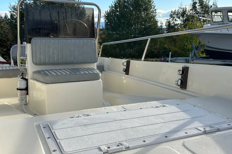 Slide: The Image of 1990 Wahoo 16.2 Striper boat interior with seating and railing, outdoors. - 12