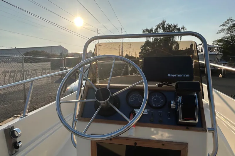 Slide: The Image of 1990 Wahoo 16.2 Striper boat dashboard with steering wheel and Raymarine equipment. - 4