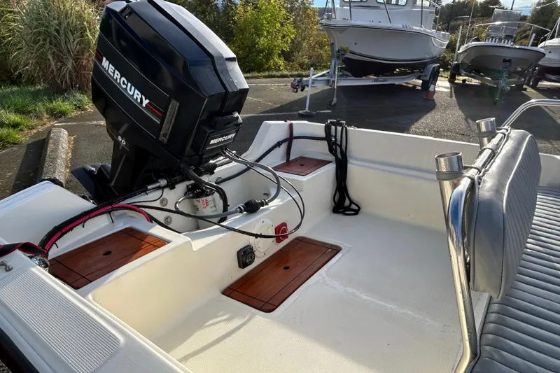 Slide: The Image of 1990 Wahoo 16.2 Striper boat with Mercury outboard motor, parked on trailer. - 6