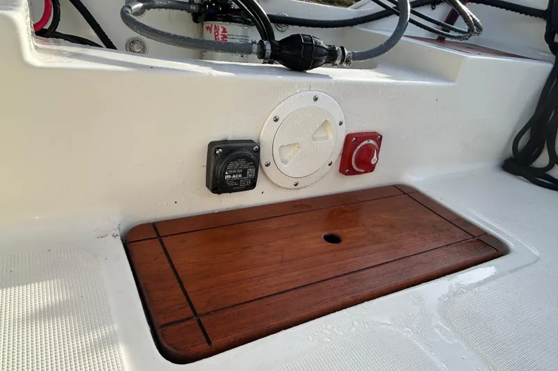 Slide: The Image of 1990 Wahoo 16.2 Striper boat deck with wooden panel and control switches. - 8