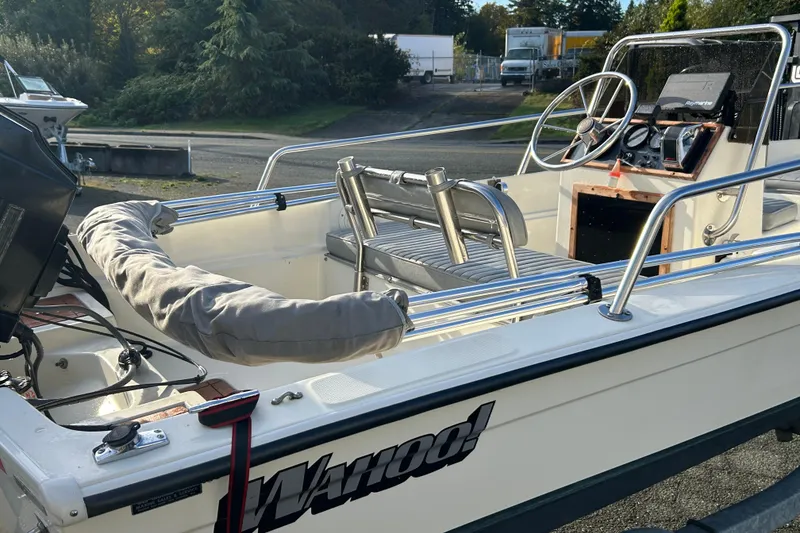 Slide: The Image of 1990 Wahoo 16.2 Striper boat with steering wheel and seating, parked outdoors. - 9